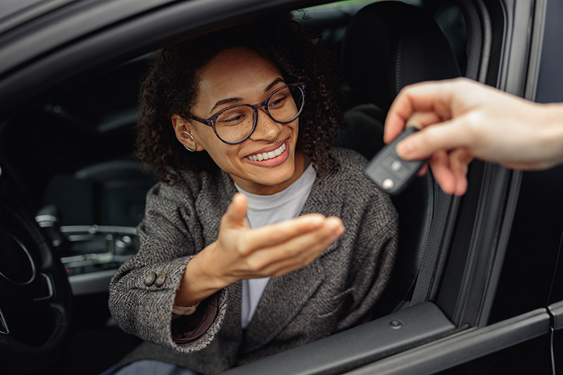 Close Up Of Car Dealer Giving Keys To Female Customer. Rent Or Purchase Of Auto Concept